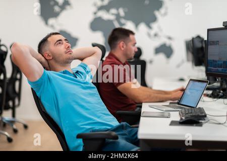 A time for relax. Young tired casual businessman relaxing at the desk in his office. Selective photo  Stock Photo