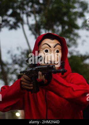The people of Palembang city wear Red Jumpsuits and wear the Salvador Dali masks from the Money Heist Serial character to entertain visitors at one of the tourist attractions in the city of Palembang, South Sumatra. Behind the costumes and colors have meaning, the red jumpsuit was also chosen because red is a symbol for revolution and has been used by many resistance groups throughout history. Meanwhile, the meaning of the masks is in addition to maintaining their original identity. Salvador Dali masks are for purposes such as democracy, feminism and the environment. (Photo by Muhammad Shahab/ Stock Photo