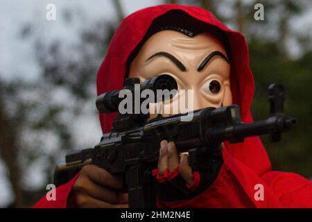 The people of Palembang city wear Red Jumpsuits and wear the Salvador Dali masks from the Money Heist Serial character to entertain visitors at one of the tourist attractions in the city of Palembang, South Sumatra. Behind the costumes and colors have meaning, the red jumpsuit was also chosen because red is a symbol for revolution and has been used by many resistance groups throughout history. Meanwhile, the meaning of the masks is in addition to maintaining their original identity. Salvador Dali masks are for purposes such as democracy, feminism and the environment. (Photo by Muhammad Shahab/ Stock Photo