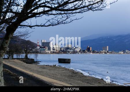 suwa, nagano, japan, 2022/06/02 , Evening view of the frozen Lake Suwa (Suwa-ko). Lake suwa is a lake in the Kiso Mountains, in the central region of Stock Photo