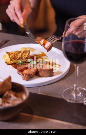 Slow cooked pork collar, cabbage, five spices, apple condiment, fine dining with a red wine Stock Photo