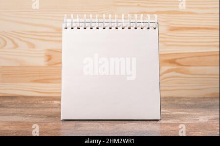 Blank notepad mockup on wooden background. Blank of brochure is on a wooden desk. Template for your design. Calendar desk mockup Stock Photo