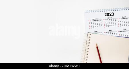 Calendar Year 2023 schedule with blank note for to do list on paper background. Flat lay with calendar. 12 months desk calendar 2023 with pen. Calenda Stock Photo