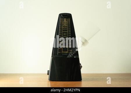 Metronome with swinging pendulum shot with motion blur effect Stock Photo