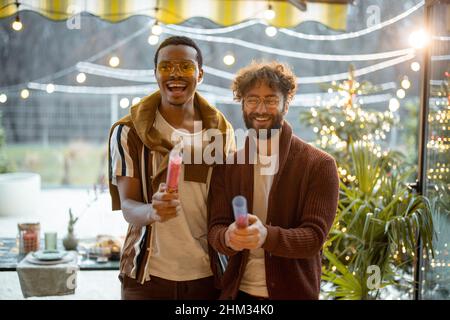Two men celebrating winter holidays at backyard Stock Photo