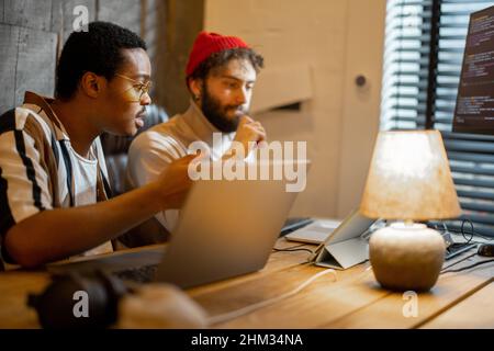 Two men working on computer at home office Stock Photo