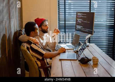 Gay couple working on computers at home office Stock Photo