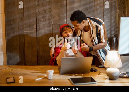 Gay couple working on computers at home office Stock Photo