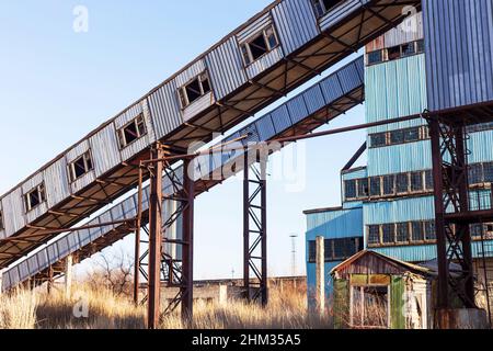 Old, abandoned concrete plant with iron rusty tanks and metal structures. The crisis, the fall of the economy, stop production capacity led to the col Stock Photo