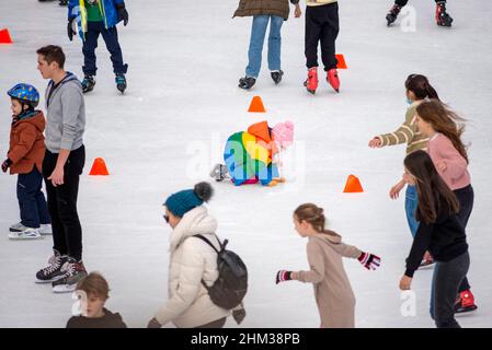 Young ice skaters at an outdoor ice skating rink Stock Photo