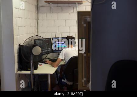 Back view of creative filmmaker working on a movie on laptop. Editing director editing a TV program Stock Photo