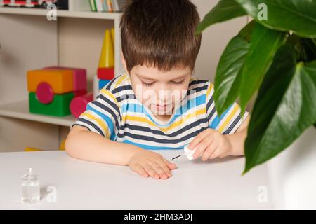 A 4-year-old boy applies nail polish to weading nail biting. Stock Photo