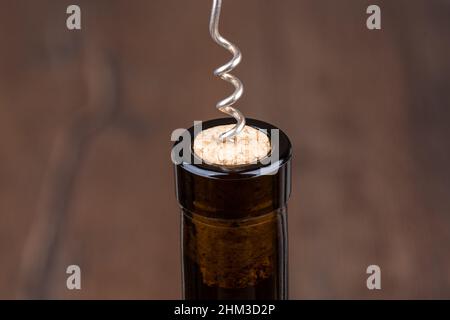 The neck of a wine bottle with a screwed corkscrew in a cork. Close up. Stock Photo