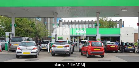 Asda supermarket sign at busy petrol station with car drivers waiting & filling up at pumps with fuel in Rugby town centre Warwickshire England UK Stock Photo