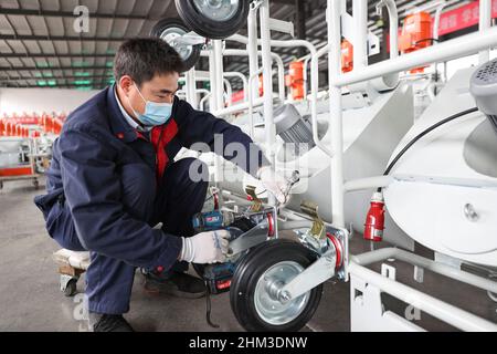 LIANYUNGANG, CHINA - FEBRUARY 7, 2022 - A worker of an enterprise produces spraying equipment for export at a workshop in Lianyungang City, East China Stock Photo