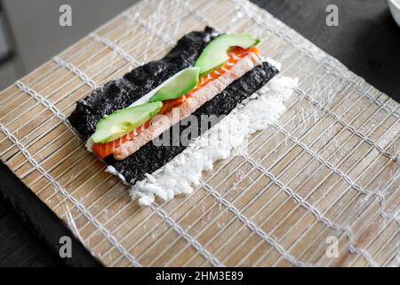 https://l450v.alamy.com/450v/2hm3e89/ingredients-of-sushi-roll-ready-for-wrapping-on-the-bamboo-mat-2hm3e89.jpg