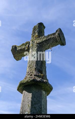 Ancient stone cross in the churchyard of St John Baptist, Chelveston, Northamptonshire, UK Stock Photo