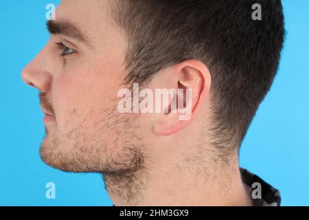 Side view photo of young man head on blue background Stock Photo