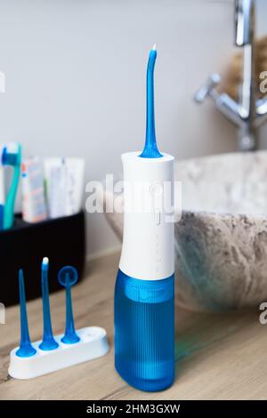 Blue home oral irrigator kit in bathroom, Waterpik for teeth cleaning, portable water flosser for dental care Stock Photo