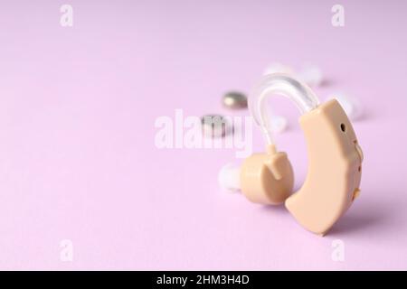 Concept of health care with hearing aid on purple background Stock Photo