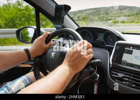 Split, Croatia - June 2021: Man driving Peugeot SUV car with hands on driving wheel Stock Photo