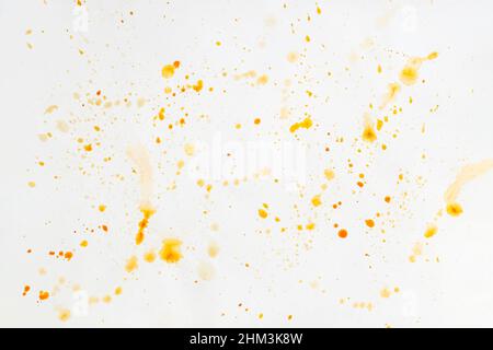 Beige and brown watercolor drops, splashes on light sheet of paper, splashed surface as background Stock Photo