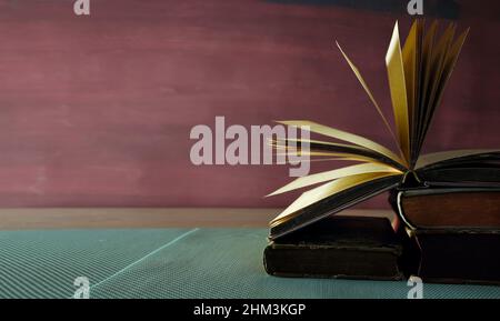 Open book, hardback book on wooden table on dark background. Back to school,education,reading. Copy space Stock Photo