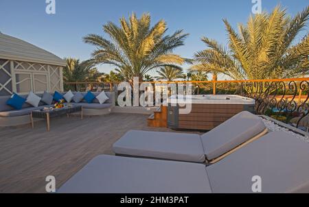 Patio roof terrace area at luxury tropical hotel resort room with sun loungers and hot tub Stock Photo