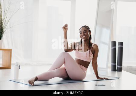 Young black woman stretching during domestic training, practicing yoga or pilates at home, free space Stock Photo