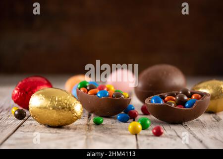 Colorful chocolate Easter eggs on wooden table Stock Photo