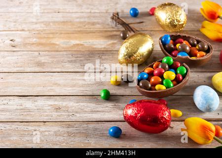 Colorful chocolate Easter eggs on wooden table Stock Photo