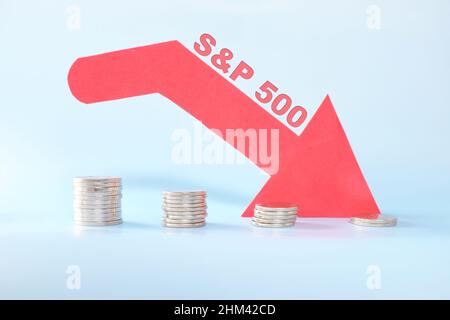 S&P 500 index in red downward arrow with decreasing stack of coins. Bearish run market in United States US stock market. Stock Photo