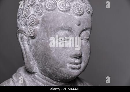 Siddharha Gautama Buddha statue made of grey stone as interior decoration, close-up portrait view Stock Photo