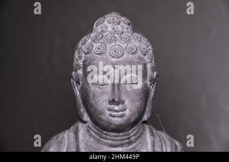 Siddharha Gautama Buddha statue made of grey stone as interior decoration, close-up portrait view Stock Photo