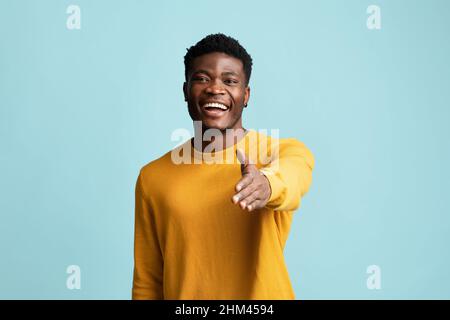 Friendly black guy outstretching hand towards camera Stock Photo