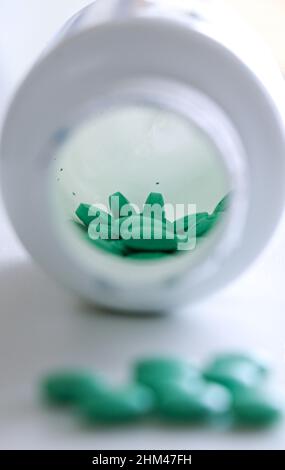 Green tablets pills in a white bottle Stock Photo