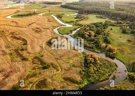 Aerial view on winding river in rural landscape during sunset. Drone view on wetlands Stock Photo