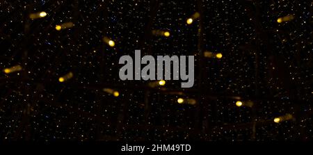Yellow light bulbs on dark hight sky background. Blurred focus. Banner. Stock Photo