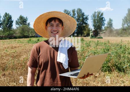 Researchers stood beside the wheat field using a computer Stock Photo