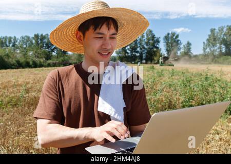 Researchers stood beside the wheat field using a computer Stock Photo