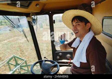 Farmers driving harvester Stock Photo