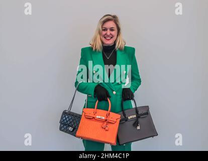 London 08 Feb 2022 Model holding (R) Orange H Ostrich  Birking 30 Hermès, 2002, estimate £8,000 – 12,000 and Black aged patent Leather Reissue Double Flap Bag Chanel, 2010-2011, a ‘re-issue’ flap bag, which has the original turnlock fastening designed by Chanel in 1955, £2,500 – 3,500,(L)A Special order bicolour Etain and Black Togo Birking 30 Hermes, 2018 estimate £7,000 – 10,000.Paul Quezada-Neiman/Alamy Live News Stock Photo