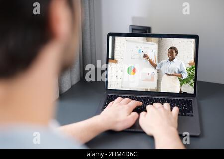Male student using app for distance video communication with female colleague, teacher, tutor, man talking with coach boss online, staying connected in pandemic, african woman leading virtual meeting Stock Photo