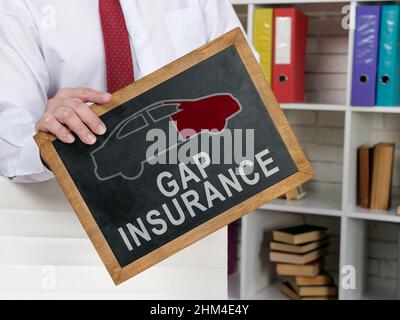 Man holds blackboard with Gap insurance words on it. Stock Photo