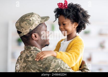 Happy Black Soldier Father And His Cute Little Daughter Embracing At Home Stock Photo