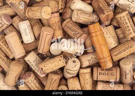 Moscow, Russia. February 7, 2022: A corkscrew on a pile of corks from bottles of different types of wine. Full frame of bottle caps. Stock Photo