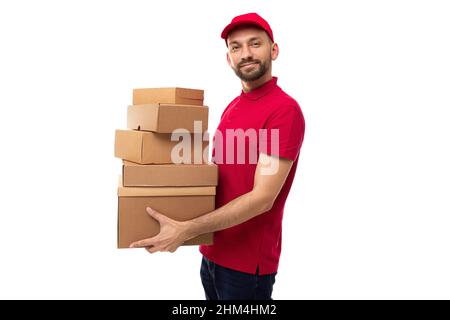 The courier of the delivery service stands in a half-turn and holds in his hands ah uphill cardboard boxes Stock Photo