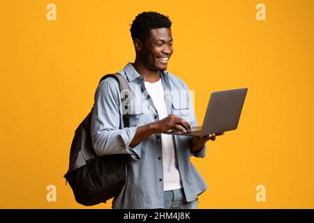 Smiling african american male student using laptop Stock Photo