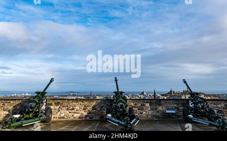 Edinburgh, Scotland, UK, 7th February 2022. UK Weather: sunshine and showers. The capital city lights up in the sunshine with a showery sky and the hint of a rainbow viewed from the ramparts of Edinburgh Castle with three L118 light field artillery guns Stock Photo