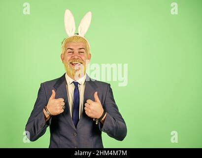 Bring out your inner rabbit. Easter rabbit. Happy businessman wear rabbit ears. Bearded man show thumbs ups. Rabbit costume party. Festive holiday Stock Photo